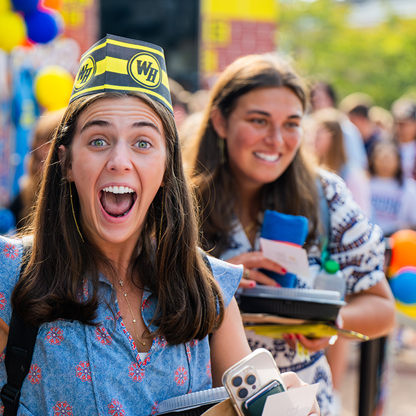 Two smiling students enjoying ice cream on the campus green 