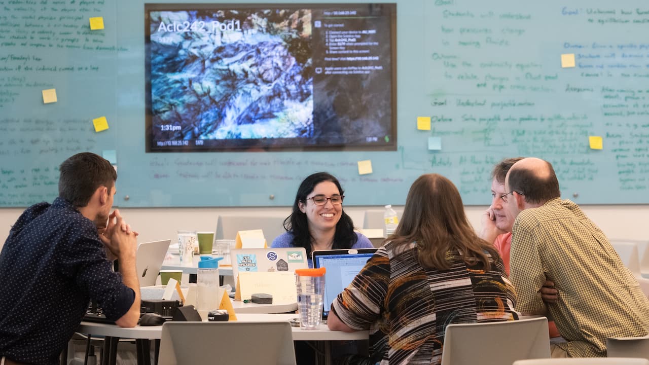students and faculty talking around a table