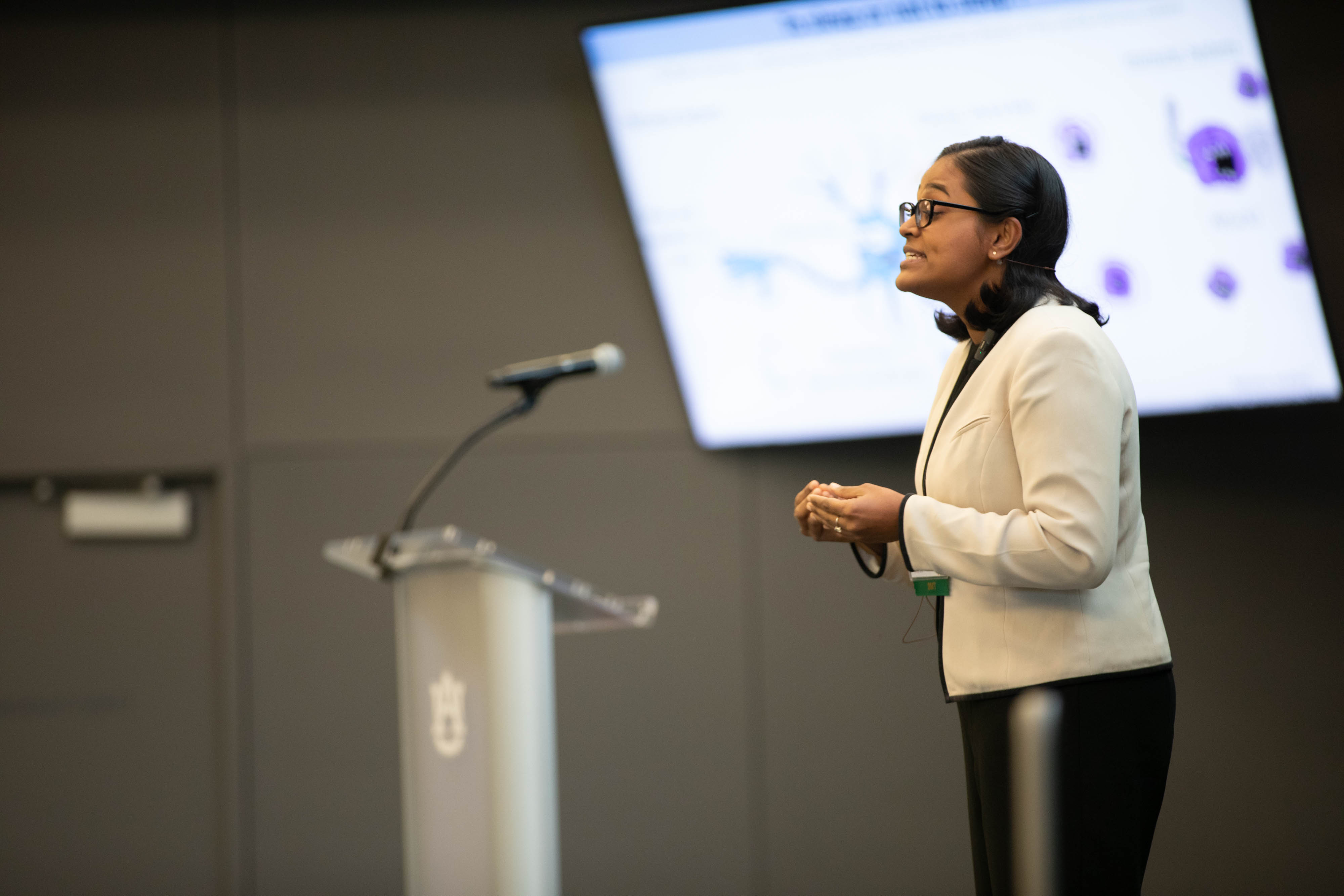 student presenter on stage at 3MT competition