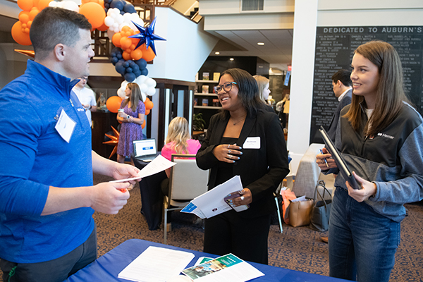 students talking to a recruiter at a career fair