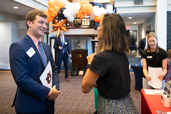 student dressed in business suit speaking to a recruiter at the career fair