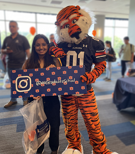 Aubie mascot and new student pose for photo at welcome event