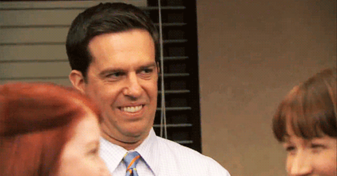 a group of people talking around an office setting, and one man with an awkward facial expression showing discomfort in the situation