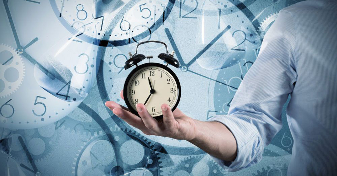 an outstretched arm with an analog alarm clock being held in a person's hand, with a blue background of multiple clock images superimposed